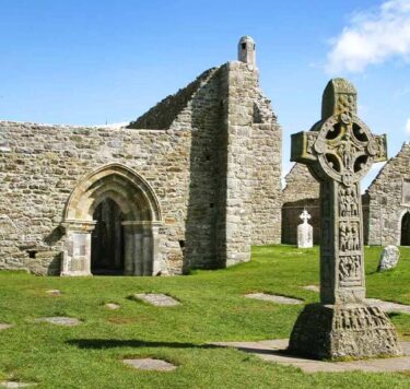Stone castle ruins of Clonmacnoise with headstones