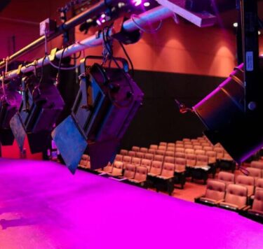 Modern theatre stage with vibrant lighting and plush seating at Dean Crowe Theatre