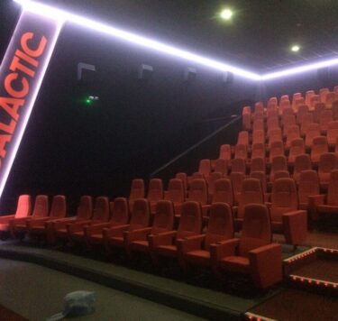 IMC cinema room with plush red seats and atmospheric lighting, perfect for guest entertainment.