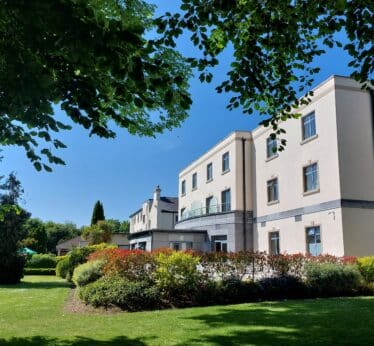 Shamrock Lodge Hotel Exterior surrounded by beautiful flowers, mature trees and manicured grounds