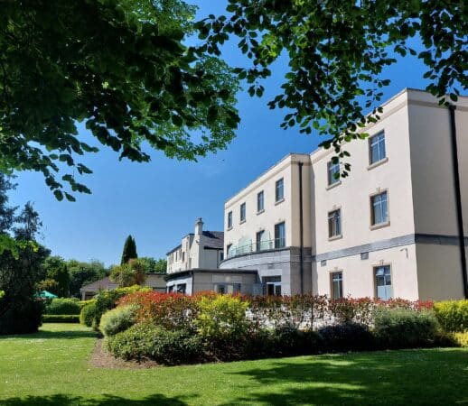 Shamrock Lodge Hotel Exterior surrounded by beautiful flowers, mature trees and manicured grounds