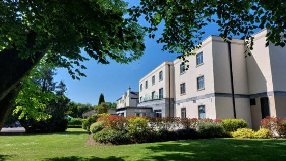 Shamrock Lodge Hotel Exterior surrounded by beautiful flowers, mature trees and manicured grounds