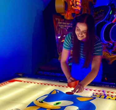 Girl enjoying air hockey in Planet Entertainment Centre
